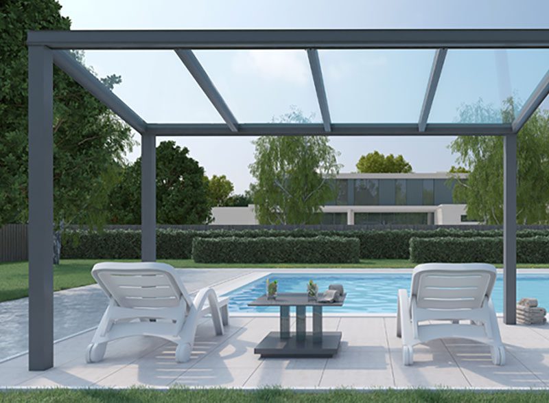 a patio with chairs and a table next to a pool.