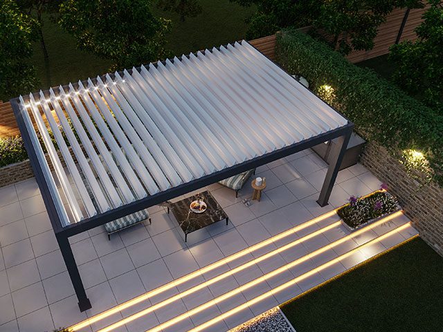 Aerial view of a modern pergola in a garden during the evening, illuminated by warm ambient lighting